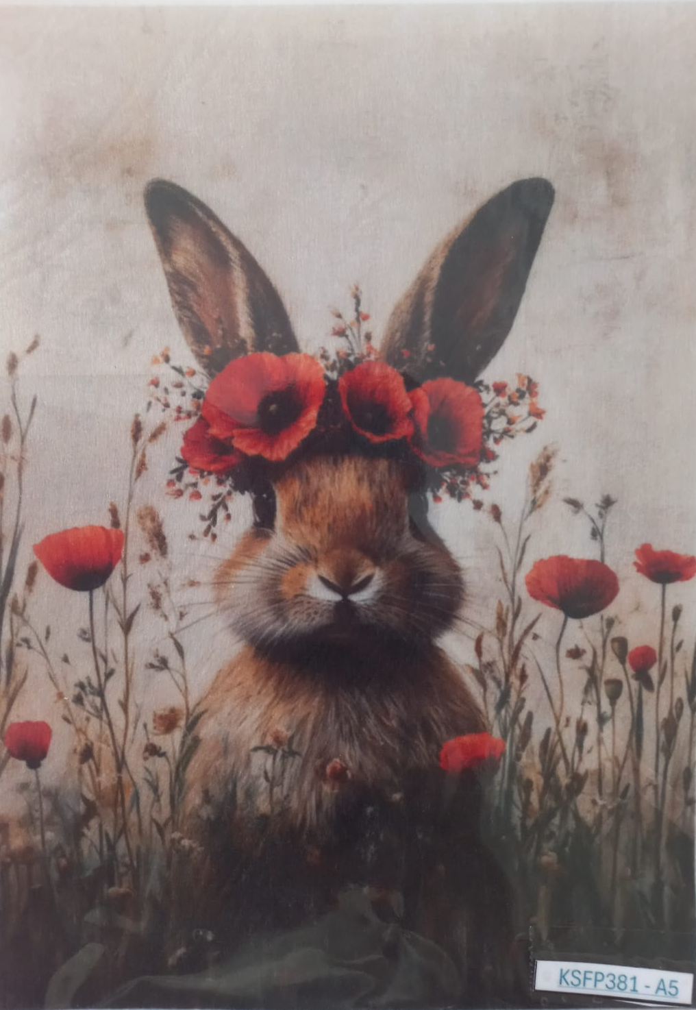A square art print or card featuring a rabbit with red poppy flowers in its ears, surrounded by red flowers on a textured beige background, photographed inside a clear protective sleeve.