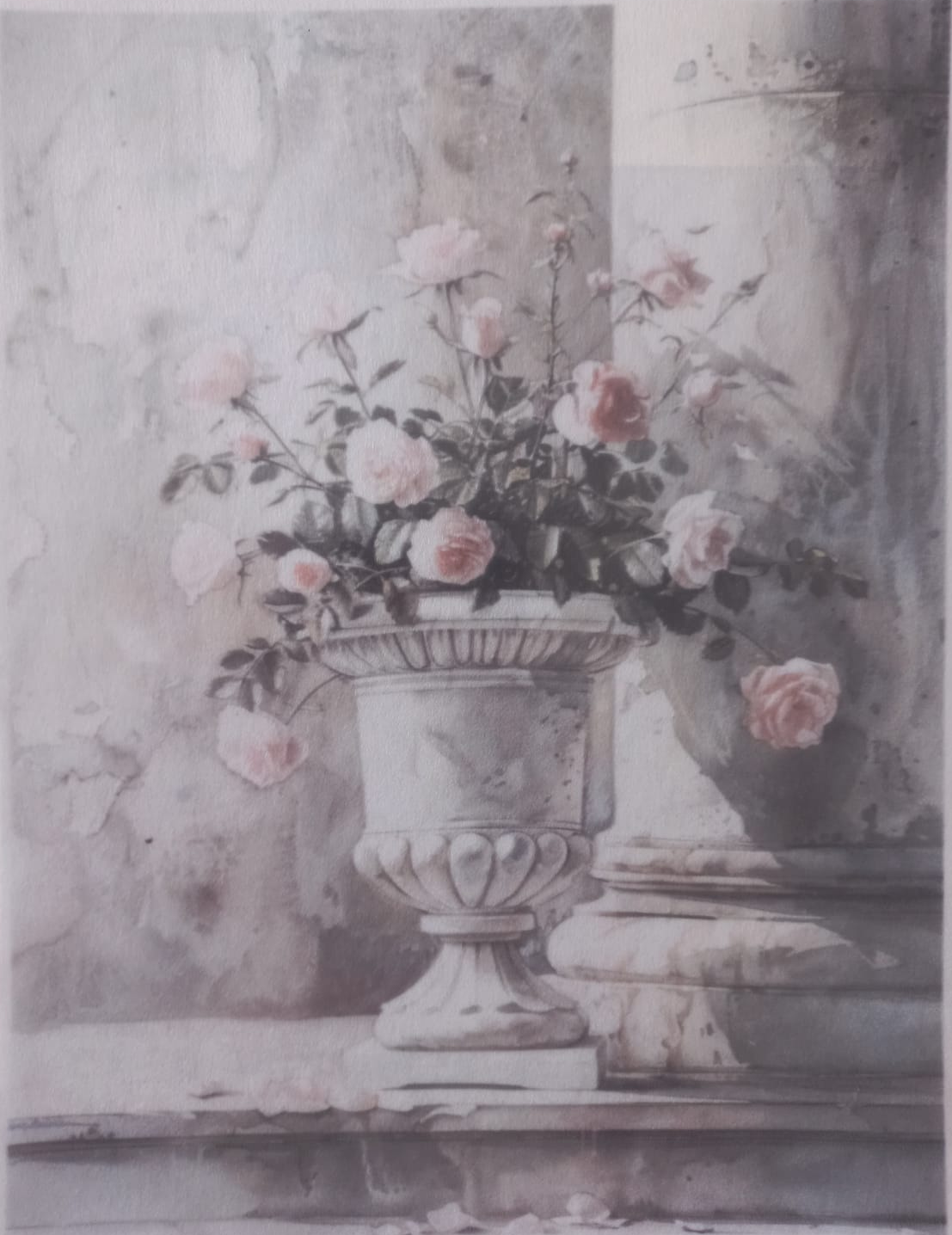 A vintage-style floral art print featuring pale pink roses arranged in an ornate white urn, with a gray stone wall and pedestal background. The print has printed text along the top and bottom edges.