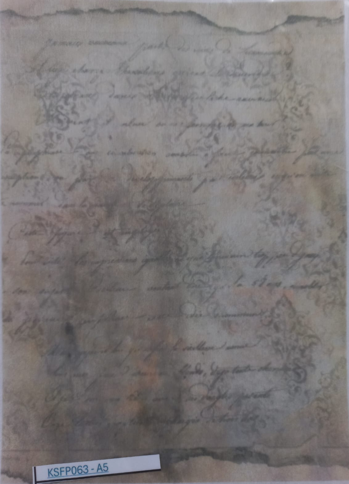 An aged, yellowed handwritten document or letter with cursive script and decorative flourishes, photographed flat against a light background. A small label at the bottom reads KSFP063-A5.
