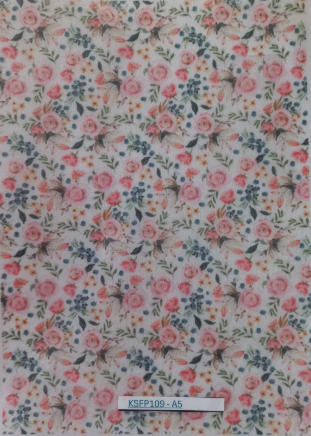 A sheet of decorative adhesive vinyl stickers featuring a dense floral and insect pattern, packaged in a clear plastic sleeve with a white backing. The pattern consists of pink and coral roses, green leaves, blue berries, and small bumblebees on a white background.