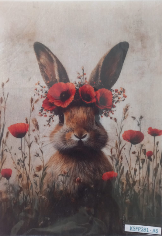A square art print or card featuring a rabbit with red poppy flowers in its ears, surrounded by red flowers on a textured beige background, photographed inside a clear protective sleeve.