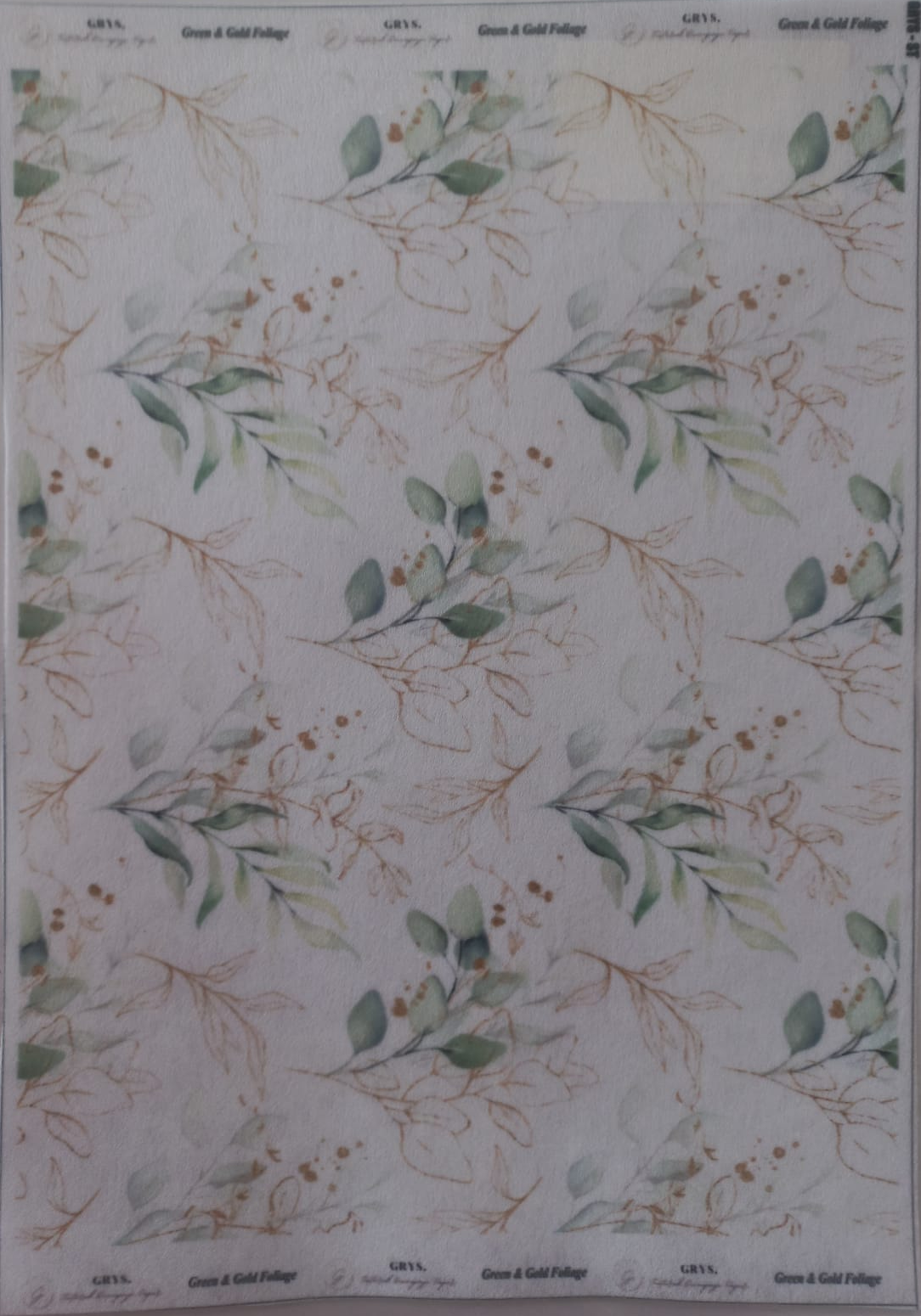 A sheet of patterned paper featuring a repeating design of green eucalyptus leaves and delicate gold botanical outlines on a white background, with 'Green & Gold Foliage' printed at the top and bottom.