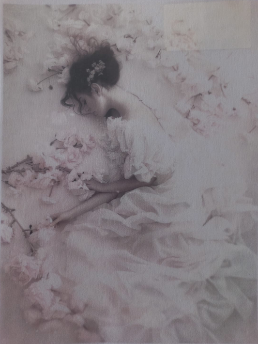 A vintage-style photographic print or poster depicting a woman in a flowing pale pink dress lying among soft pink flowers, shown against a white border with small printed text along the top and bottom.