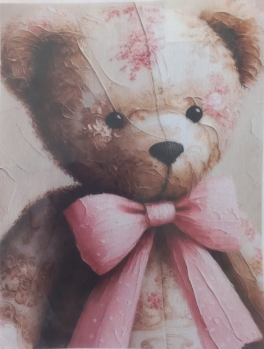 A close-up of a teddy bear illustration or print featuring a brown bear with a large pink bow, cream face, and soft pink floral details on a textured background.