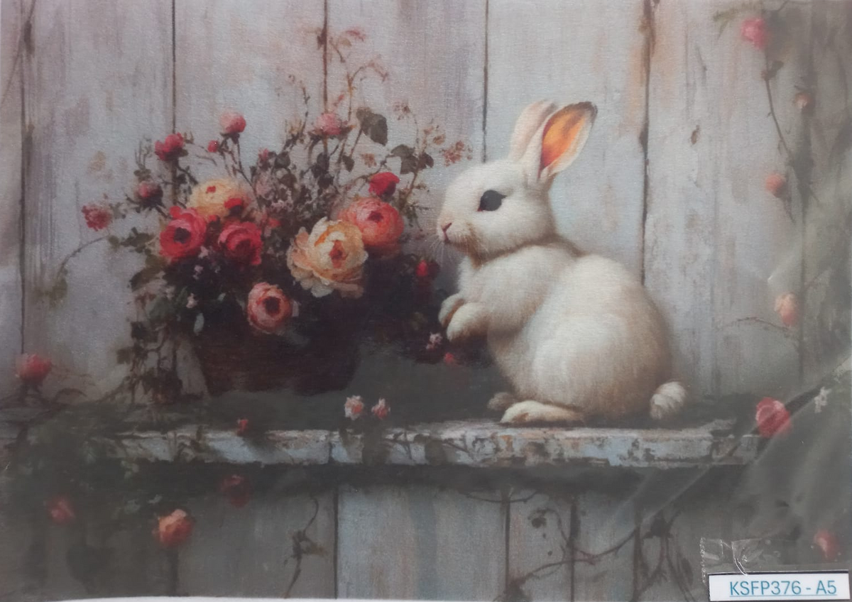 A square art print or card featuring a white rabbit sitting on a weathered wooden ledge beside a bouquet of pink and red flowers, set against a rustic gray wooden plank background. A small label reading KSFP376-A5 is visible in the bottom right corner.