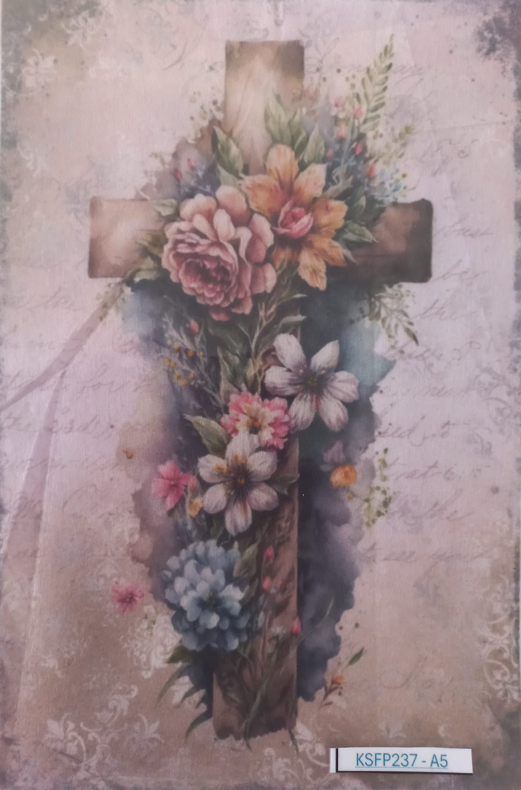 A square decorative art print or card featuring a watercolor-style floral cross. The design shows a rustic cross adorned with layered flowers in soft pink, peach, white, blue, and green tones over a distressed beige and dusty rose background.