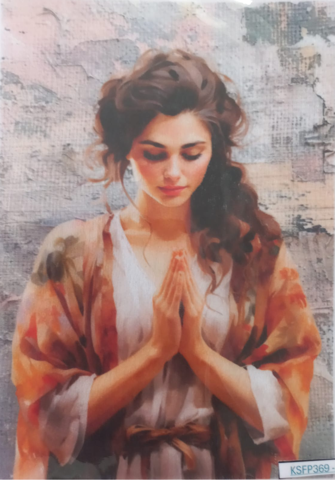 A rectangular art print or card featuring a painted portrait of a woman in prayer, with her hands together in front of her face. She wears a white robe with orange and brown watercolor-like accents.