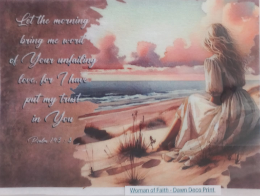 A square art print or decal featuring a watercolor-style scene of a woman sitting on a beach at sunset, with the text 'Let the morning bring me word of Your unfailing love, for I have put my trust in You Psalm 142:3' on the left. The print is photographed against a white background with a small label at the bottom reading 'Woman of Faith - Dawn Deco Print.